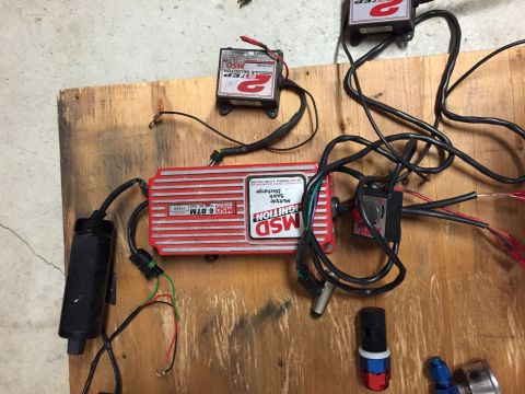 1988 Ford Bronco - Various MSD ignition components, including an MSD 6 BTM box, are laid out on a wooden surface.