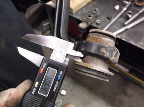 1999 Mercury Grand Marquis - Measuring suspension bushing with digital calipers, reading 10.64 inches.