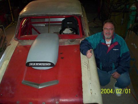 1963 Ford Falcon - A man poses with a modified 1963 Ford Falcon, a prominent hood scoop and interior roll cage.