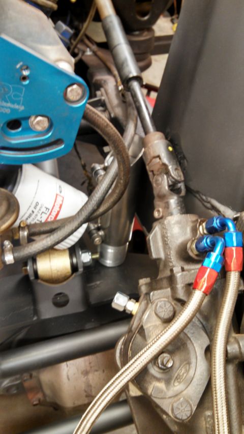 1967 Ford F-250 - Vehicle steering column and power steering unit with braided hoses and an oil filter visible.