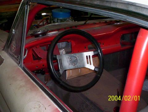1963 Ford Falcon - Interior view of a 1963 Ford Falcon, modified with a roll cage and racing steering wheel.