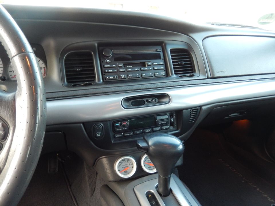 Car interior center dash with factory radio, automatic shifter and two aftermarket gauges