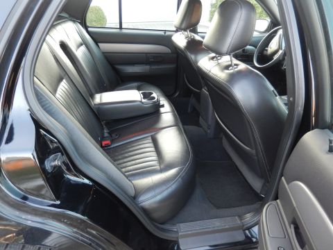2003 Mercury Marauder - Interior view of a black car's rear seats, showing the leather upholstery and a center console with a cup holder.