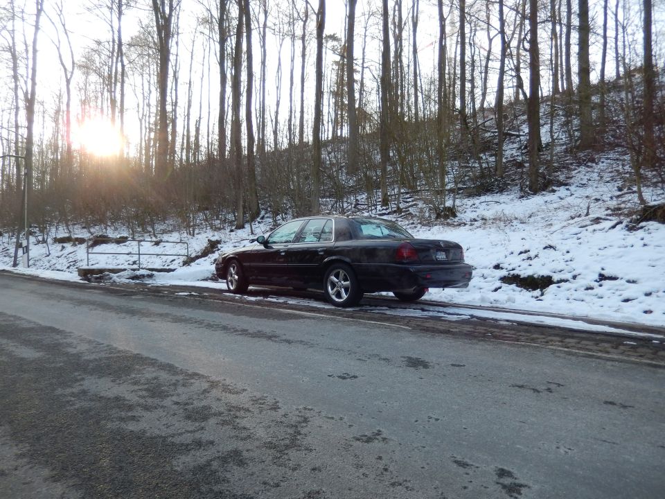 Black 2003 Mercury Marauder parked on a snowy roadside, rear view
