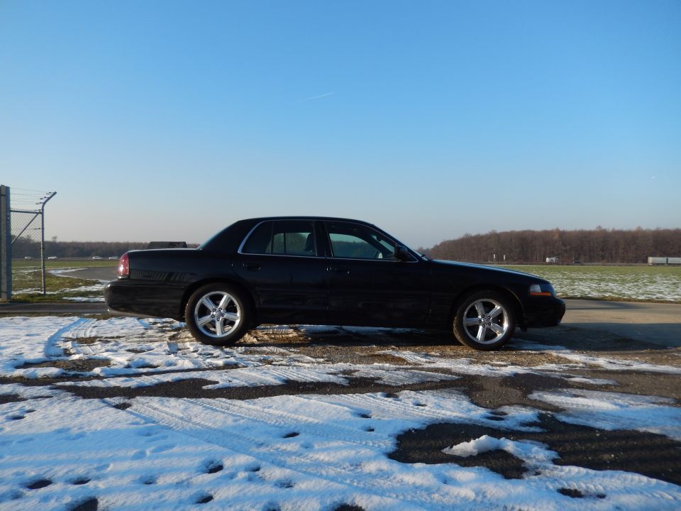 Side view of a black 2003 Mercury Marauder parked on a snowy road