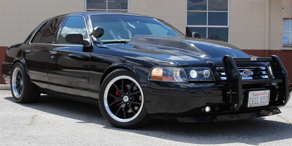 Black Ford Crown Victoria sedan with push bar, black wheels and EVIL VIC plate