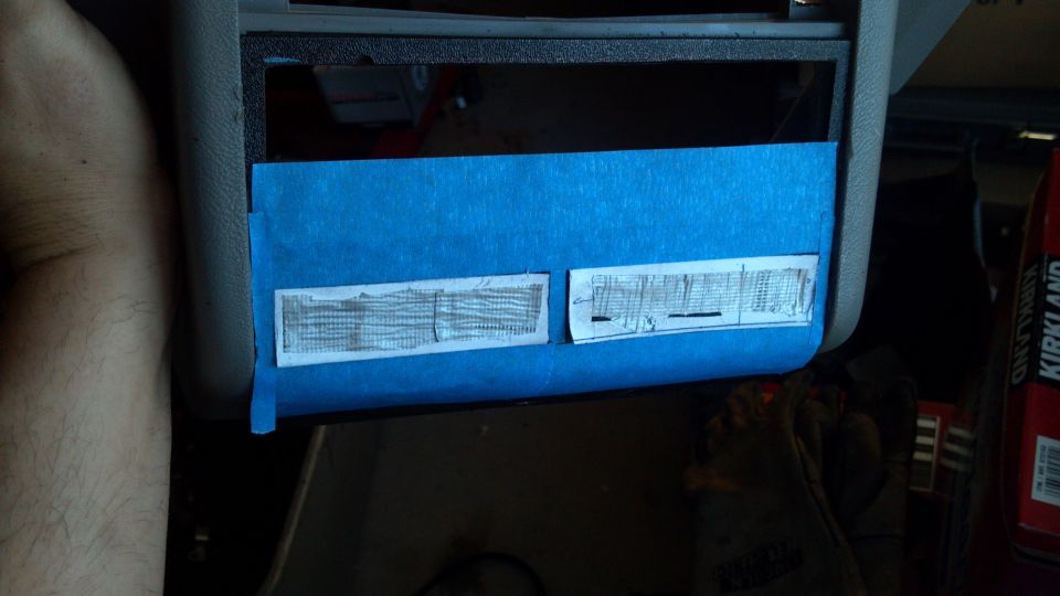 Close-up of car's dashboard with blue tape covering two small labels with text