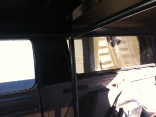 1995 Ford Bronco - Interior of a vehicle, possibly a Bronco, with a roll cage installed. Supermotors logo visible.