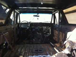 1995 Ford Bronco - The interior of a Ford Bronco shows a roll cage and a disassembled dashboard.