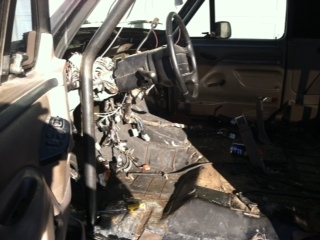 1995 Ford Bronco - The interior of a vehicle shows exposed wiring and a disassembled dashboard area.