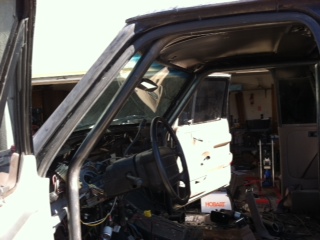 1995 Ford Bronco - The interior of a truck is shown with the doors open, revealing the steering wheel and dashboard area.