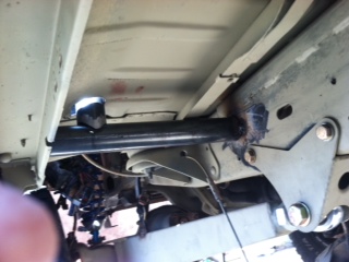 1995 Ford Bronco - Close-up view of the vehicle's undercarriage, showing structural components and signs of wear.