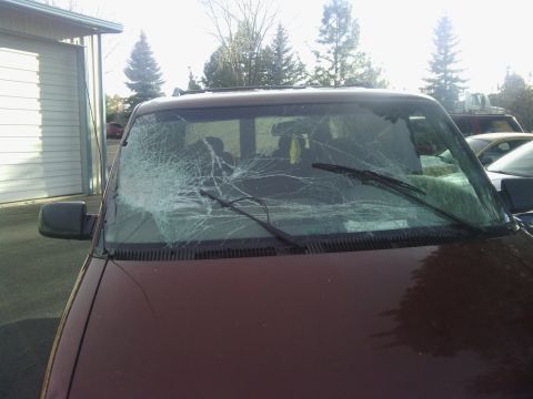 2000 Chevrolet Astro - Front view of a maroon 2000 Chevrolet Astro van showing a heavily damaged windshield.
