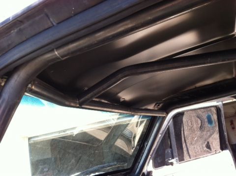 1995 Ford Bronco - The photo shows the interior of a vehicle with a custom-installed roll cage, focusing on the roof and windshield frame.