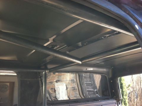 1995 Ford Bronco - Custom roll cage installed inside a vehicle, with a view through the rear window.