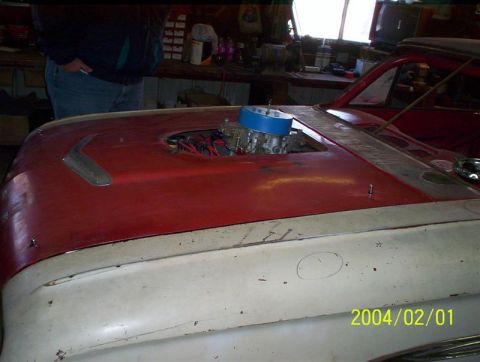 1963 Ford Falcon - This 1963 Ford Falcon shows its engine with a prominent carburetor visible through the hood opening.
