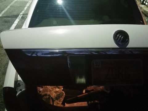 2000 Mercury Grand Marquis - The trunk of a 2000 Mercury Grand Marquis is open, revealing its contents and the license plate.