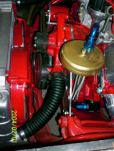 1963 Ford Falcon - This image shows various engine components, including a ribbed belt and a flexible hose connected to a brass cap.