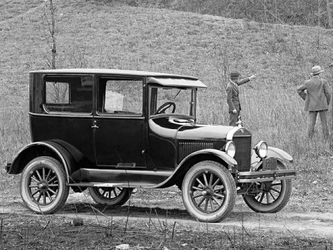 1909 Ford Model T - A black sedan from 1926 is parked outdoors with two men observing in the background.