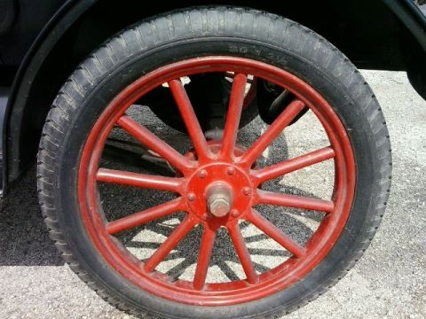 1909 Ford Model T - A close-up view of a red spoked wheel and tire on a 1909 Ford Model T.