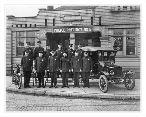 1909 Ford Model T - Police officers pose with a 1917 Ford Model T and a motorcycle in front of their precinct.