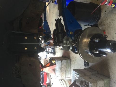 1994 Ford Bronco - A detailed view of a vehicle's suspension and braking system, showing components being worked on in a garage setting.