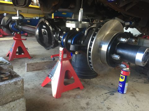 1994 Ford Bronco - Close-up of a vehicle's rear axle assembly being worked on, with brake components visible.