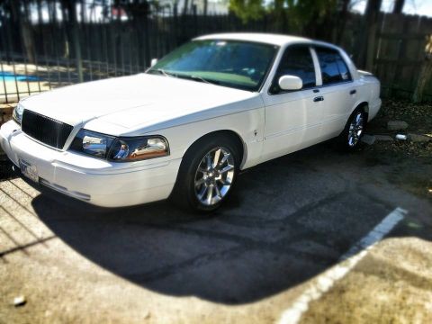 2000 Mercury Grand Marquis - This white sedan, likely a 2003 model, is viewed from the front three-quarter angle.