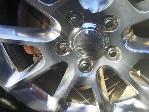 2000 Mercury Grand Marquis - Close-up of a shiny wheel hubcap displaying the Mercury emblem.