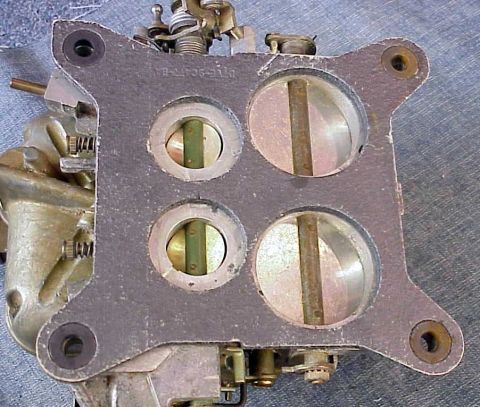 1972 Ford Ranchero - A close-up view of a four-barrel carburetor, showing the internal throttle plates and external mechanical components.