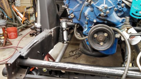 1967 Ford F-250 - The engine and chassis of a vehicle are visible in a workshop setting, with tools nearby.