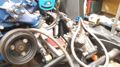 1967 Ford F-250 - Close-up view of engine and steering system components, including a blue engine block and a black steering gear.