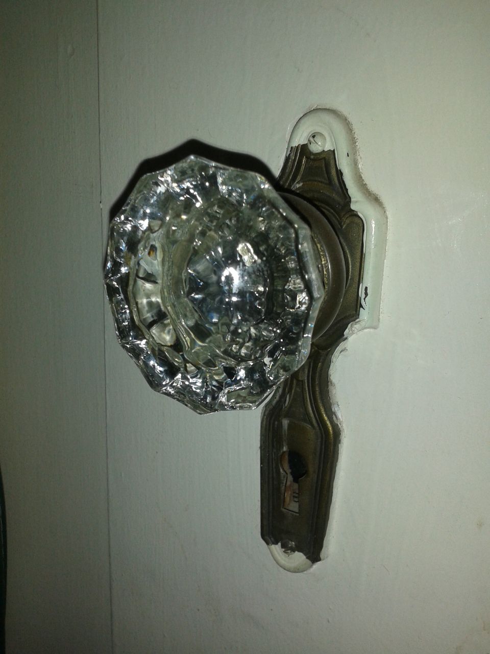 Glass doorknob with ornate brass plate and keyhole