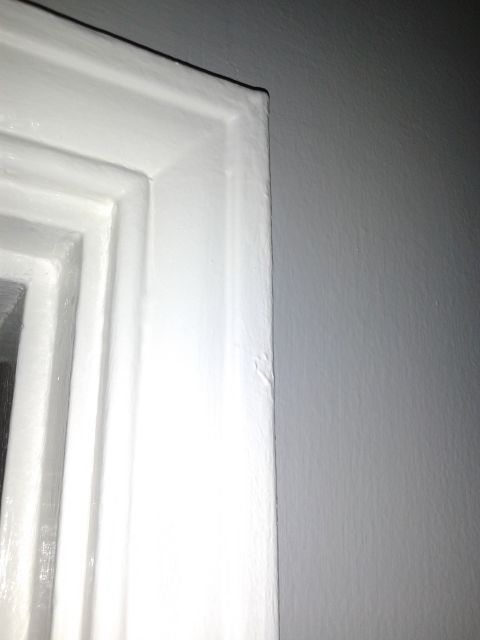 1990 Ford Bronco - The corner of a painted door frame is shown against a textured gray wall.