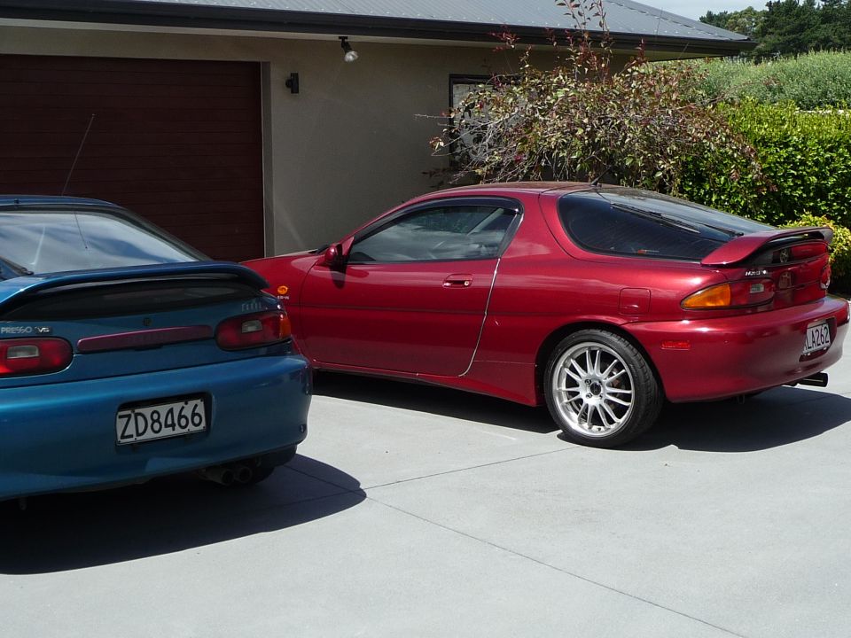 Red 1993 Mazda MX-3 rear quarter panel and alloy wheel