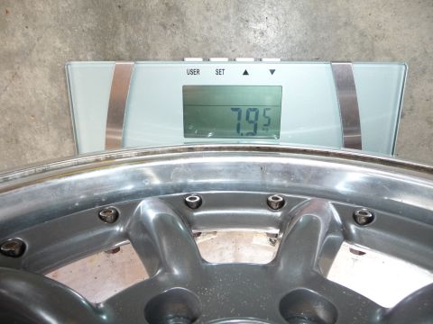 1993 Mazda MX-3 - A close-up view of a car wheel being weighed on a digital scale.