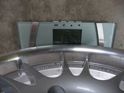 1993 Mazda MX-3 - A car wheel's weight is measured on a digital scale, displaying 79.5.
