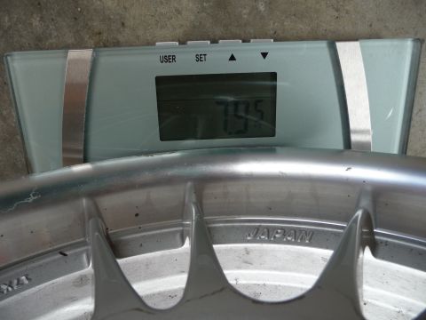 1993 Mazda MX-3 - A wheel is placed on a digital scale, showing a weight of 79.5. The wheel is marked with 'JAPAN'.