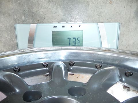 1993 Mazda MX-3 - A close-up shows a wheel being weighed on a digital scale, which displays 73.5 lbs.