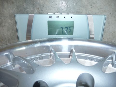 1993 Mazda MX-3 - A car wheel is placed on a digital scale, showing a weight of 7.75 kg.
