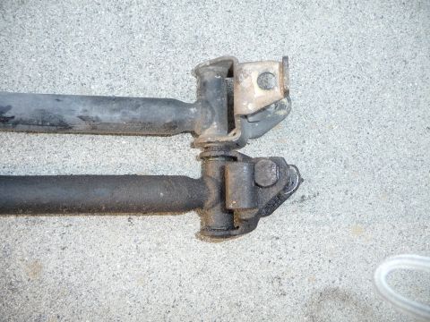1993 Mazda MX-3 - Close-up view of two automotive suspension components laid out on a textured concrete ground.