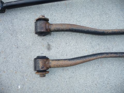 1993 Mazda MX-3 - Close-up of two aged suspension control arms, showing wear and rust on the metal components.