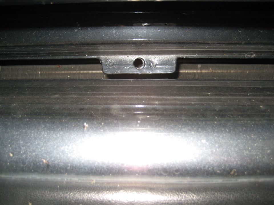 close-up of a black plastic clip with a hole on a car's grille