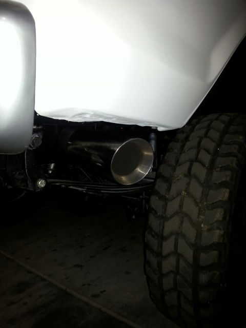1979 Ford Bronco - Detail shot of a vehicle's exhaust pipe and off-road tire.