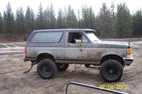 1990 Ford Bronco - Side view of a muddy 1990 Ford Bronco off-road.