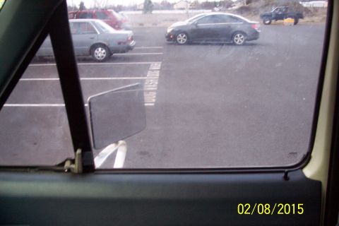 1990 Ford Bronco - Parking lot scene with multiple vehicles visible through a car window.