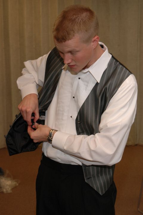1985 Ford Crown Victoria LTD - A man is seen adjusting his vest while preparing for an event.