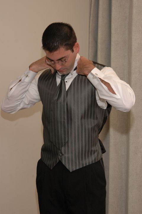 1985 Ford Crown Victoria LTD - Man getting dressed in formal wear, adjusting his tie and collar.