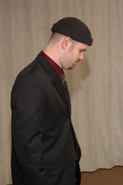 1985 Ford Crown Victoria LTD - A man in formal attire with a beanie is captured in a profile view against a neutral backdrop.