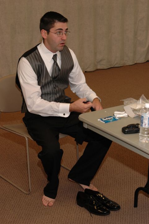 1985 Ford Crown Victoria LTD - A man dressed for a formal occasion sits at a table with a bottle of water and other items.